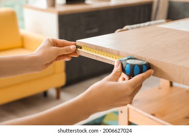 Young woman taking measures of table in kitchen, closeup - Powered by Shutterstock