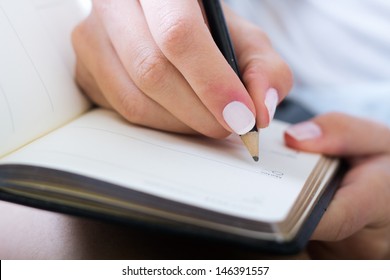 Young Woman Taking Notes At Home