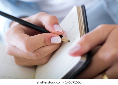 Young Woman Taking Notes At Home