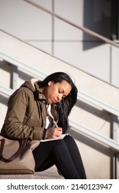 Young Woman Taking Notes Outside Work Offices