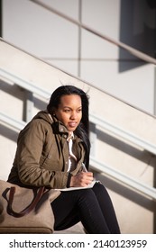 Young Woman Taking Notes Outside Work Offices