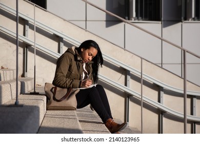 Young Woman Taking Notes Outside Work Offices