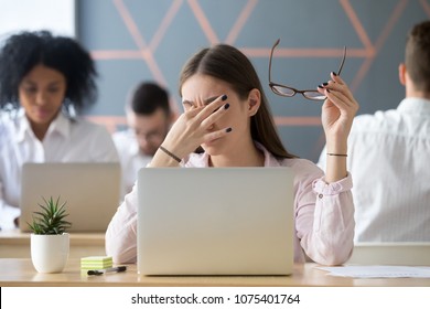 Young Woman Taking Off Glasses Tired Of Computer Work, Exhausted Student Or Employee Suffering From Eye Strain Tension Or Computer Blurry Vision Problem After Long Laptop Use, Eyes Fatigue Concept