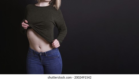 Young Woman Taking Off Sweater In Teasing And Provocative Way