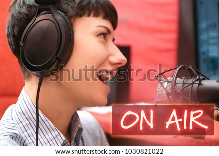 Young woman taking part in live radio broadcast at modern studio