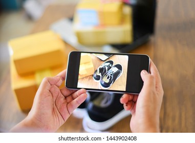young woman taking photo sneakers with camera smartphone for post to sell online on the internet market website / selling online ecommerce shipping online shopping delivery and order concept - Shutterstock ID 1443902408