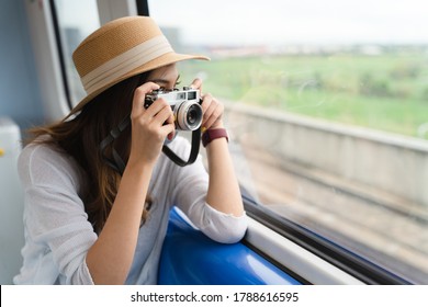 young woman taking photo while travel by train.