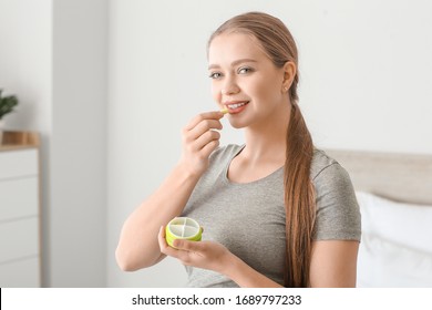 Young Woman Taking Pill At Home