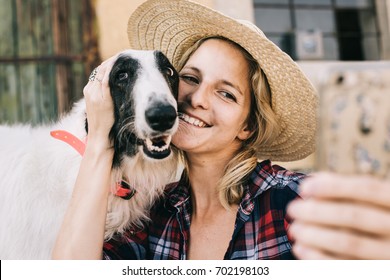 Young woman taking self portrait wit her dog for social media profile picture