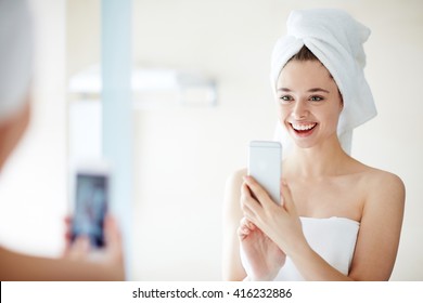 Young Woman Taking Selfie In Front Of Mirror In The Bathroom