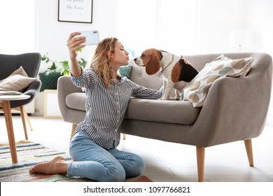 Young Woman Taking Selfie With Her Dog At Home