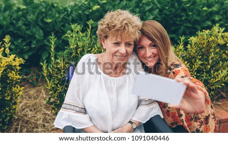 Similar – Woman taking selfie with older mother in wheelchair