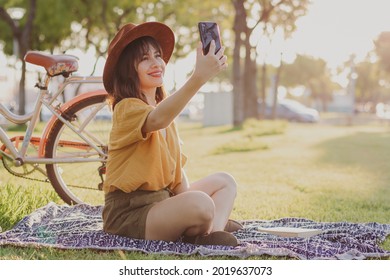 Young Woman Taking A Selfie In A Park Golden Hour Bike In The Background