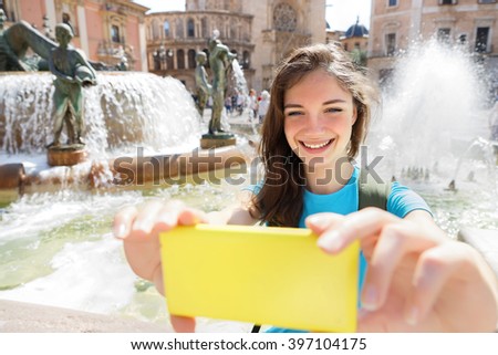 Young woman taking selfie portrait selfie photo on Europe travel. Happy candid tourist on Valencia, Spain. Travel and tourism concept.