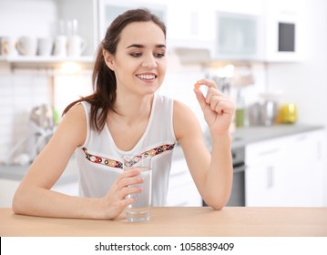 Young Woman Taking Vitamin Pill Indoors