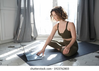 Young Woman Taking Yoga Classes Online At Home.Beautiful Young Girl With Curly Hair Exercises Online.Yogini Sitting In Lotus Pose Near Computer.Download Curated Royalty Free Collection Of Yoga Images