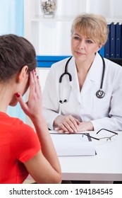 Young Woman Talking About Headache To Female Doctor