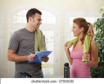 Young Woman Talking With Her Personal Trainer At Home.