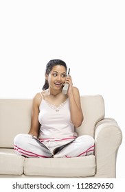 Young Woman Talking On A Cordless Phone And Holding A Magazine