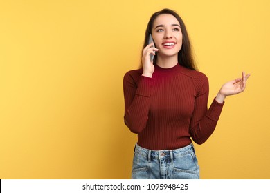 Young Woman Talking On Phone Against Color Background