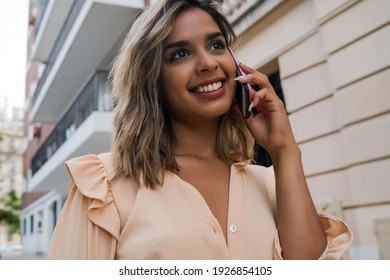 Young woman talking on the phone outdoors. - Shutterstock ID 1926854105