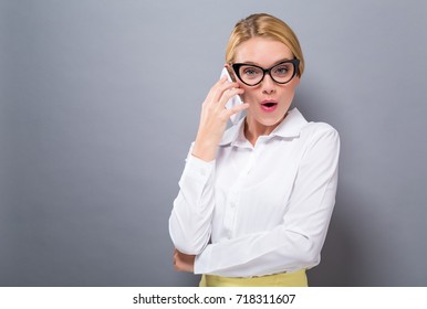 Young Woman Talking On The Phone On A Solid Background