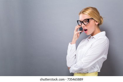 Young Woman Talking On The Phone On A Solid Background