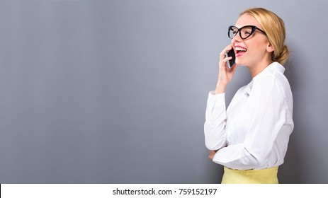 Young Woman Talking On The Phone On A Solid Background