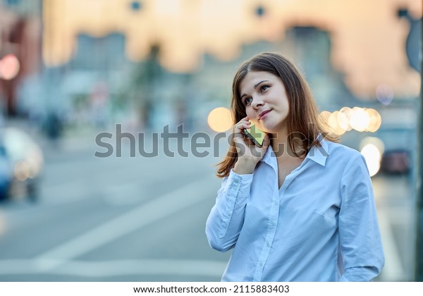 Young woman talks\
by handy on traffic\
street.