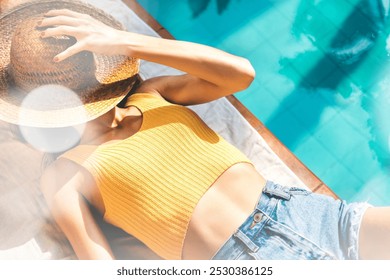 Young woman tanning at a summer poolside. Woman enjoying freedom and outdoor activity. Summer vacation. Travel and wellbeing lifestyle. Wanderlust and summertime holidays concept. - Powered by Shutterstock