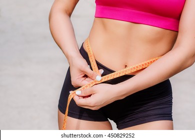 Young Woman With Tape Measure Around Waist