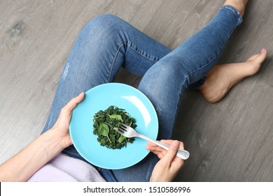 Young woman with tasty cooked spinach on wooden floor, closeup. Healthy food - Shutterstock ID 1510586996