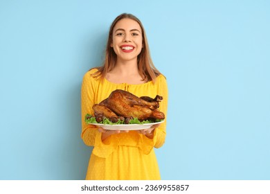 Young woman with tasty turkey on blue background. Thanksgiving Day celebration - Shutterstock ID 2369955857
