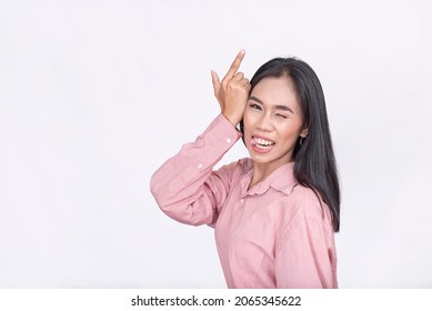 A young woman taunting by making a loser gesture while sticking her tongue out. Possibly lighthearted banter. - Shutterstock ID 2065345622
