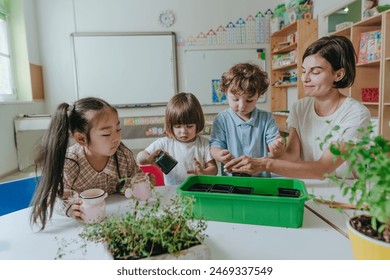 Young woman teacher with children in kindergarten plants a plant in a pot. Selective focus. - Powered by Shutterstock