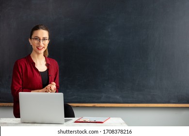 Young Woman Teacher With His Laptop In Classroom.