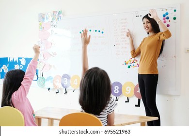 Young woman teacher teaching kids in kindergarten classroom, preschool education concept