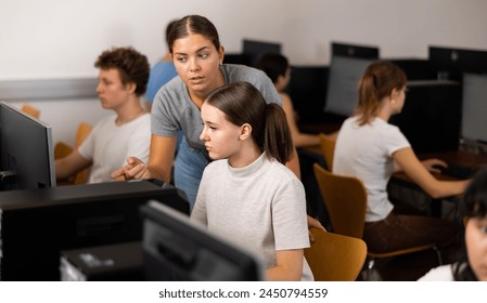 Young woman teacher and teenage girl studying computer science in classroom in school. - Powered by Shutterstock