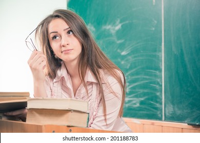 Young Woman Teacher Thinking At Class Blackboard