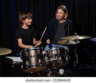 Young woman teaching boy to play drums. - Powered by Shutterstock