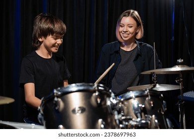 Young woman teaching boy to play drums. - Powered by Shutterstock