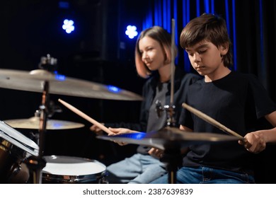 Young woman teaching boy to play drums. - Powered by Shutterstock