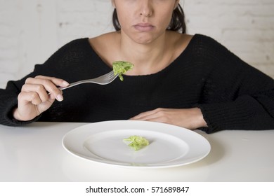 Young Woman Or Teen With Fork Eating Dish With Ridiculous Little Lettuce As Her Food Symbol Of Crazy Diet In Nutrition Disorder Concept Anorexia And Bulimia Refusing To Eat In Diet Calories Obsession 