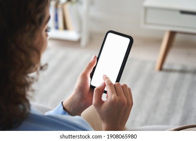 Young woman or teen girl hands holding cell phone touching finger mockup white blank display, empty screen for social media app ad at home. Mobile application tech concept, over shoulder closeup view.