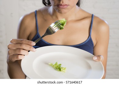 Young Woman Or Teen Girl Holding Dish With Ridiculous Little Lettuce As Her Food Symbol Of Crazy Diet In Nutrition Disorder Concept Anorexia And Bulimia And Refusing To Eat In Diet Calories Obsession 