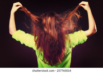 Young Woman Teen Girl Pulling Her Long Brown Hair On Black. Back View