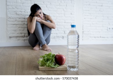 Young Woman Or Teenager Girl Sitting On Ground Alone And Worried At Home Suffering Nutrition And Eating Disorder In Diet And Weight Loss Obsession With Healthy Food In Anorexia And Bulimia Concept