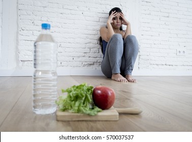 Young Woman Or Teenager Girl Sitting On Ground Alone And Worried At Home Suffering Nutrition And Eating Disorder In Diet And Weight Loss Obsession With Healthy Food In Anorexia And Bulimia Concept