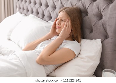 Young Woman With Terrible Headache Lying In Bed