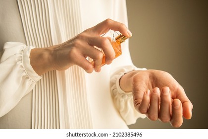 Young woman testing and applying parfume